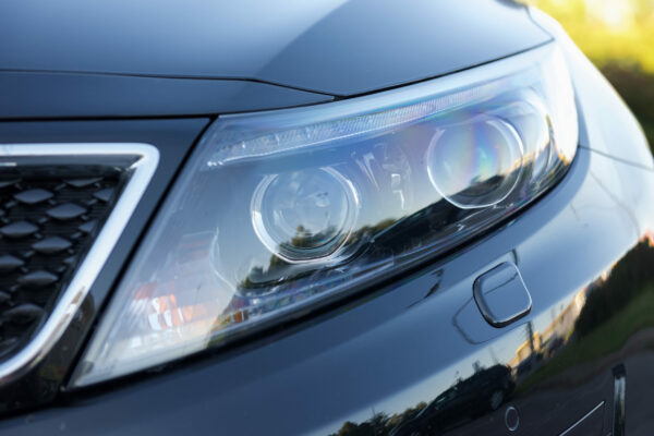 Luxury car headlight- closeup view, background.