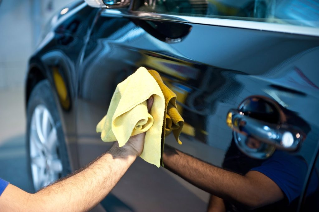 Hand drying car paint with microfiber towel during exterior detailing service in Nashville